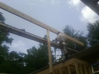 Carpenter setting a ridge beam over a new addition frame — Ice Dam Removal by Roofing Brothers in Olar