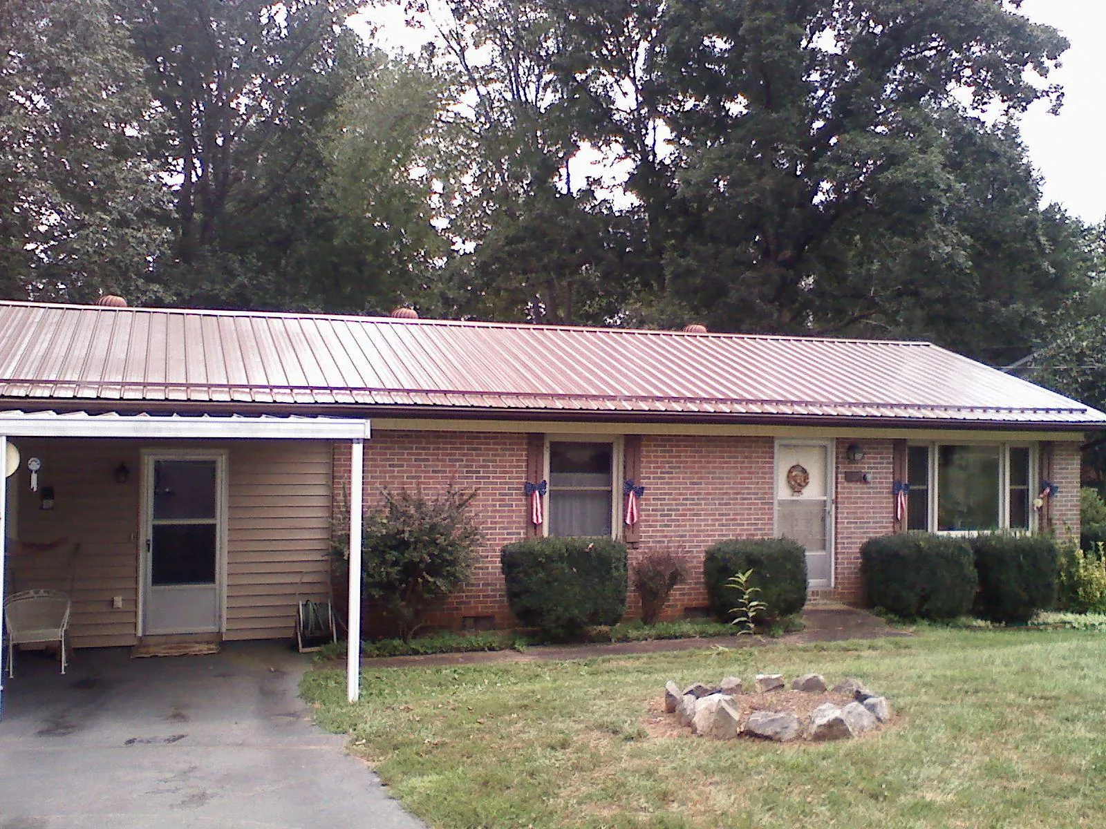 Bronze metal roof and carport on a brick ranch home — Roof Repair work by our crew in Olar