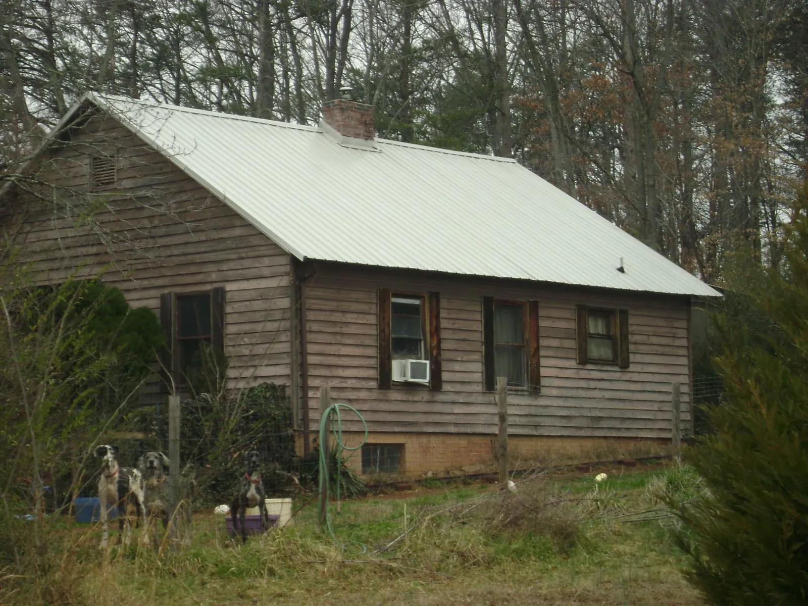 White metal roof on an old wood sided farmhouse, from a Metal Roof Installation job in Olar